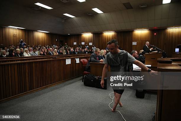 Oscar Pistorius walks across the courtroom without his prosthetic legs during the third day of Oscar's hearing for a resentence at Pretoria High...