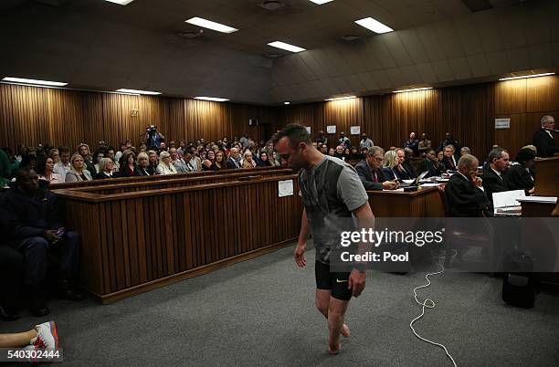 Oscar Pistorius walks across the courtroom without his prosthetic legs during the third day of Oscar's hearing for a resentence at Pretoria High...