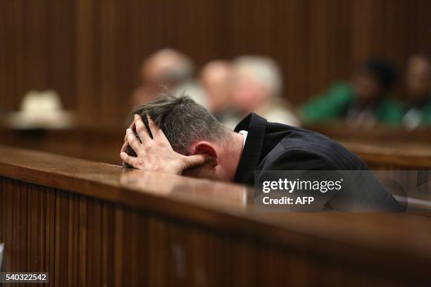 South African Paralympian Oscar Pistorius holds his head in his hands during his resentencing hearing for the 2013 murder of his girlfriend Reeva...