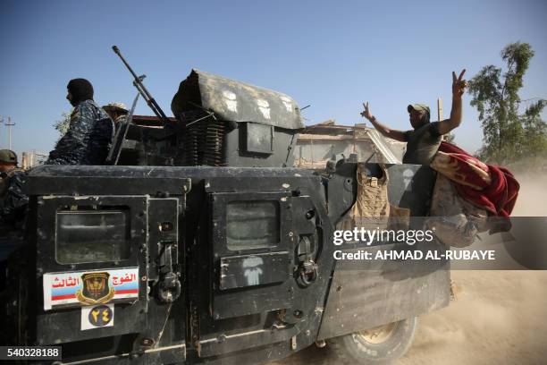 Member of Iraqi government forces flashes the sign of victory in the back of an armoured vehicle during an operation, backed by air support from the...