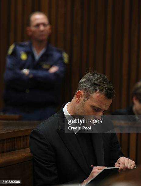 Oscar Pistorius takes notes during the third day of Oscar's hearing for a resentence at Pretoria High Court on June 15, 2016 in Pretoria, South...