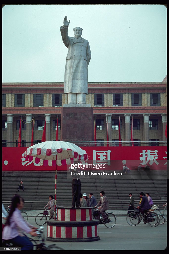 Traffic Officer Works Below Statue of Chairman Mao