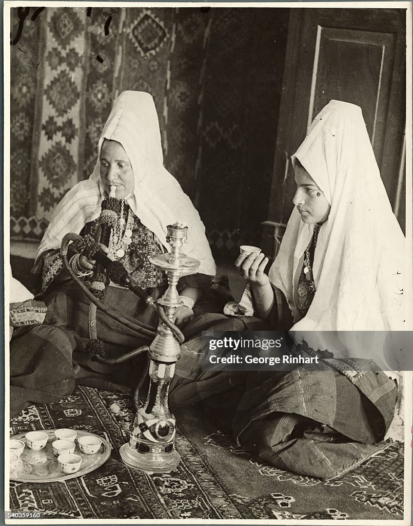 Women Sitting on Floor With Middle Eastern Smoking Pipe