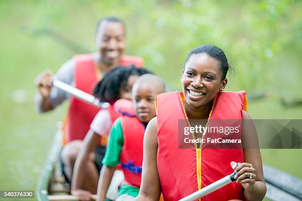 family on a canoe trip - family red canoe stock pictures, royalty-free photos & images