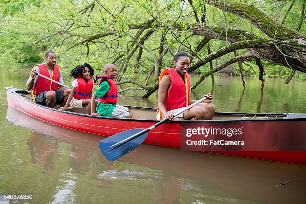 canoeing on a lake in canada - family red canoe stock pictures, royalty-free photos & images