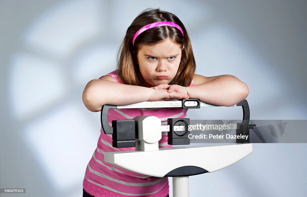 Disappointed overweight girl on scales