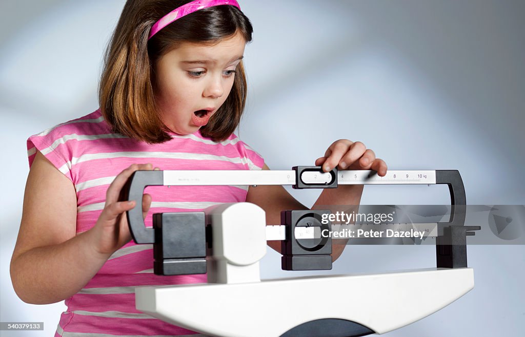 Shocked overweight girl on scales