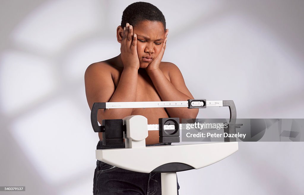 Obese boy weighing himself