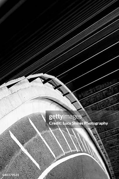 curve in road with white lines and railings - lucy shires stock-fotos und bilder