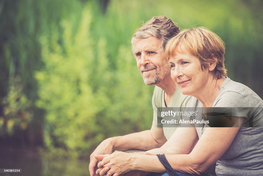 Senior caucasian couple outdoors portrait - looking around