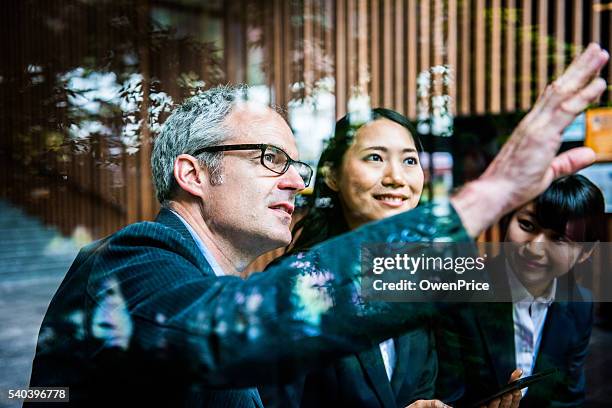 englishman discussing concept with japanese team - sponsor stockfoto's en -beelden