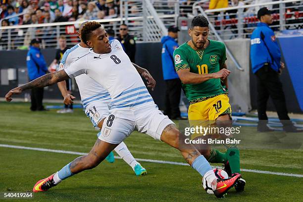Abel Hernandez of Uruguay blocks a kick by Joel McAnuff of Jamaica during a group C match at Levi's Stadium as part of Copa America Centenario US...