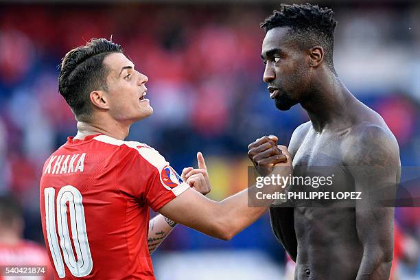 Switzerland's midfielder Granit Xhaka speaks with Switzerland's defender Johan Djourou after a 1-1 draw following the Euro 2016 group A football...