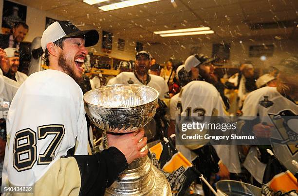 Sidney Crosby of the Pittsburgh Penguins celebrates with the Stanley Cup and teammates in the locker room after winning Game 6 of the 2016 NHL...