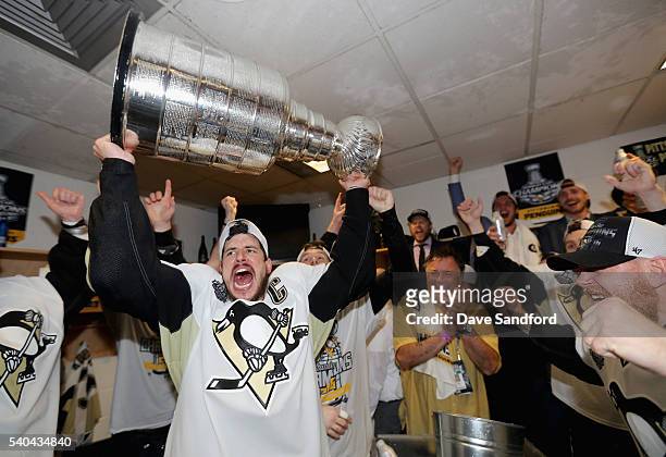 Sidney Crosby of the Pittsburgh Penguins celebrates with the Stanley Cup and teammates in the locker room after winning Game 6 of the 2016 NHL...