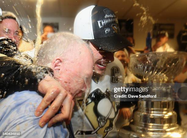 General manager Jim Rutherford of the Pittsburgh Penguins embraces Sidney Crosby in the locker room after the Penguins won Game 6 of the 2016 NHL...