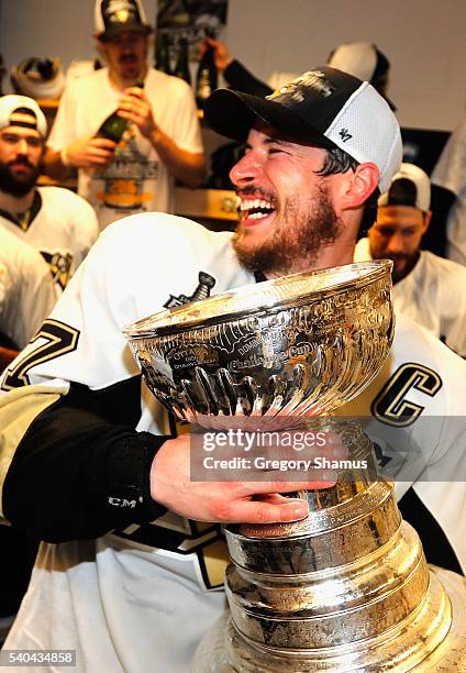 Sidney Crosby of the Pittsburgh Penguins celebrates with the Stanley Cup and teammates in the locker room after winning Game 6 of the 2016 NHL...