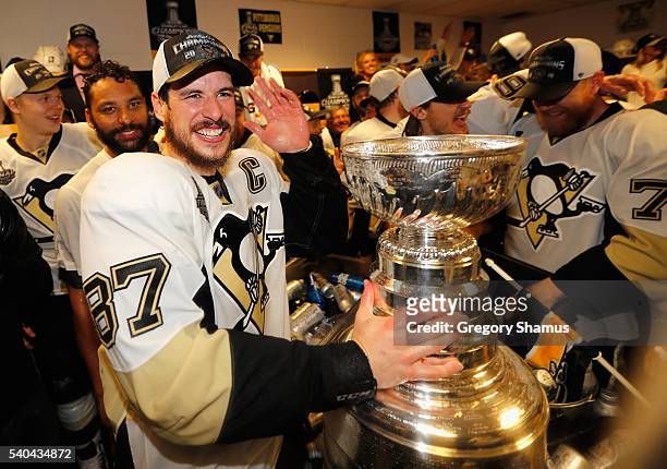 Sidney Crosby of the Pittsburgh Penguins celebrates with the Stanley Cup and teammates in the locker room after winning Game 6 of the 2016 NHL...