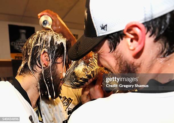 Sidney Crosby and Kris Letang of the Pittsburgh Penguins celebrate with the Stanley Cup in the locker room after winning Game 6 of the 2016 NHL...