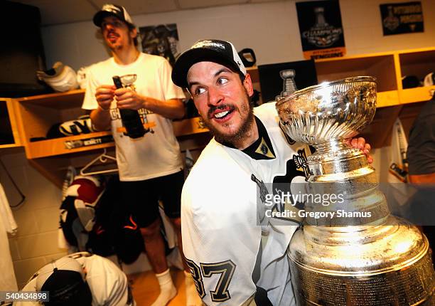 Sidney Crosby and teammate Evgeni Malkin of the Pittsburgh Penguins celebrate with the Stanley Cup in the locker room after winning Game 6 of the...