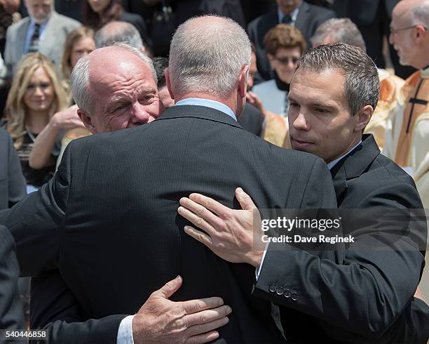 Mark Howe and his son Travis Howe hug Marty Howe after carrying out their dad Gordie Howe during the funeral at the Cathedral of the Most Blessed...