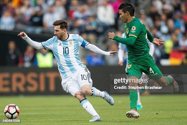 Lionel Messi, left, of Argentina and Diego Bejarano of Bolivia chase down the ball during a group D match between Argentina and Bolivia at...