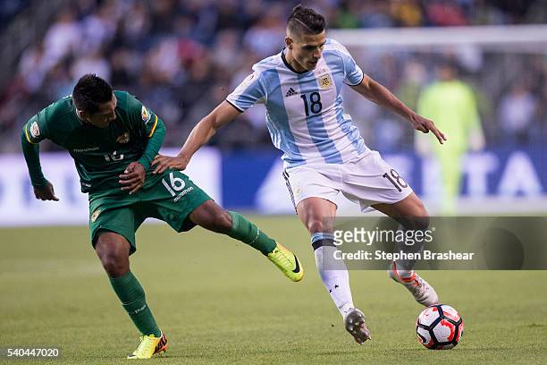 Erik Lamela of Argentina dribbles the ball as Cristhian Machado of Bolivia challenges him during a group D match between Argentina and Bolivia at...