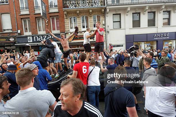 English fans celebrate with beer outside a pub in the city center on June 15, 2016 in Lille, France. Football fans from around Europe have descended...