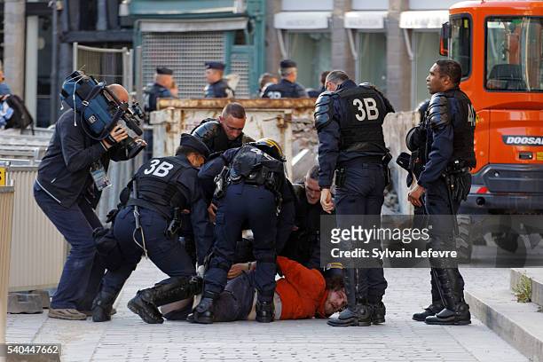 Police arrest a football fan in the city center on June 15, 2016 in Lille, France. Football fans from around Europe have descended on France for the...