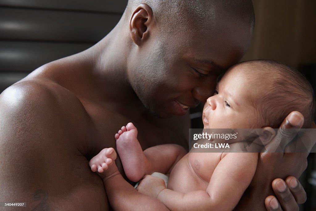 Father cuddling newborn baby