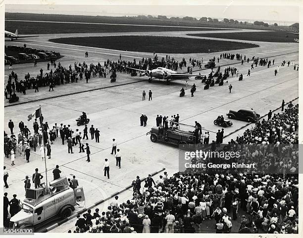 With a number of motorcycle policeman as an escort Howard Hughes, brings his mammouth plane to rest on the runway of the Floyd Bennett airport, just...