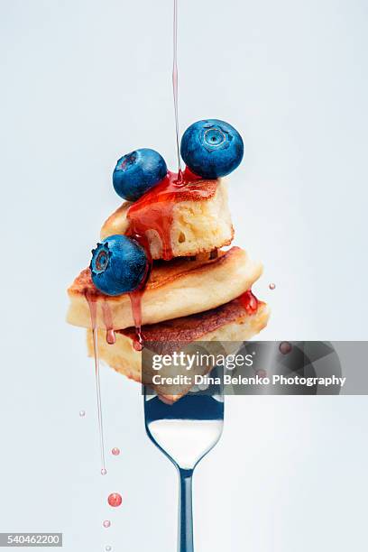 blueberry pancakes with syrup on fork - pancakes stock-fotos und bilder