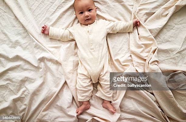 boy laying on bed. - babygro stock pictures, royalty-free photos & images