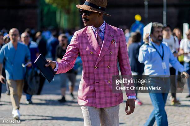 Guest wearing a pink plaid blazer jacket during Pitti Uomo 90 on June 15 in Florence, Italy