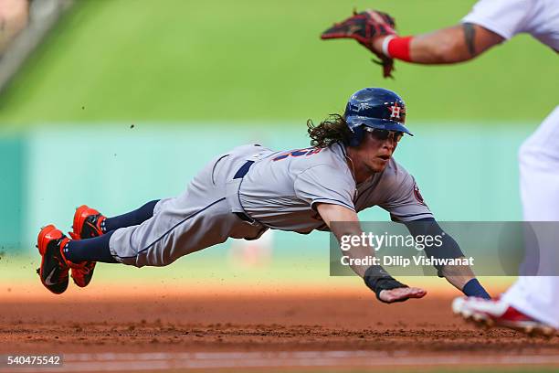 Colby Rasmus of the Houston Astros dives back to first base in an attempt to avoid being doubled up against the St. Louis Cardinals in the second...