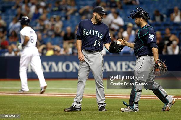 Pitcher Nathan Karns of the Seattle Mariners speaks to catcher Chris Iannetta after walking Desmond Jennings of the Tampa Bay Rays to load the bases...