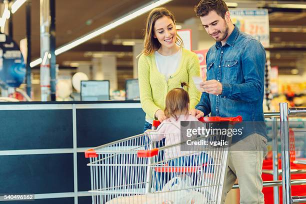 family groceries shopping in local supermarket. - bonnetje stockfoto's en -beelden