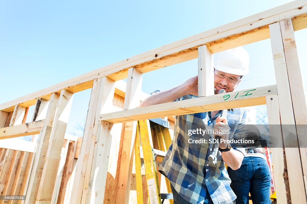 Hombre Trabajador de construcción utiliza Martillo en el lugar de trabajo