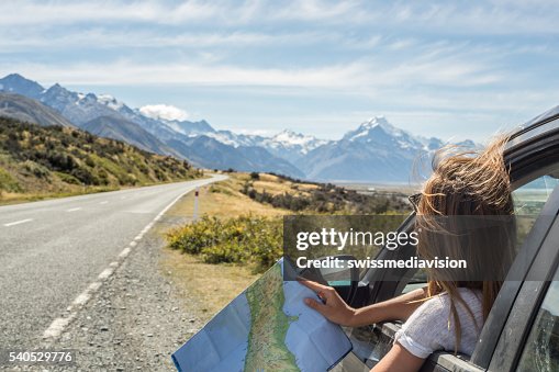 Portrait of young woman in car looking at map Portrait of young woman in car looking at map