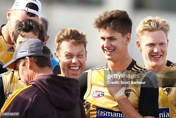 Sam Mitchell of the Hawks laughs as Alastair Clarkson, coach of the Hawks speaks and Daniel Howe and James Sicily of the Hawks look on during a...