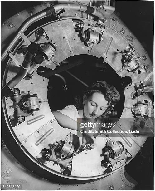Part of the cowling for one of the motors for a B-25 bomber is assembled in the engine department of North American's Inglewood, California plant by...