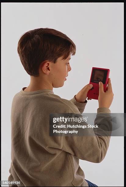 10-year-old boy playing video game - handheld video game stock pictures, royalty-free photos & images