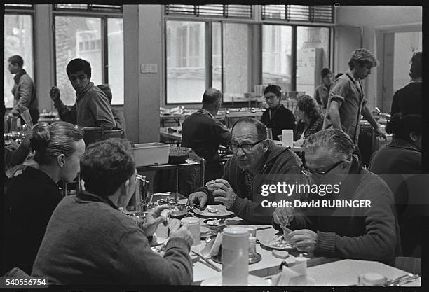 Men and women eat in the dining hall at Kibbutz Givat-Brenner in Israel.