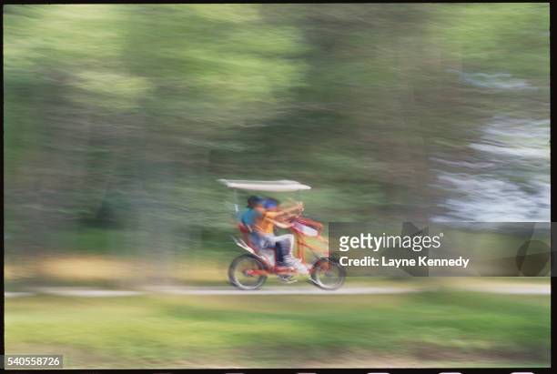 bicyclists riding a quadricycle on algonquin island - quadricycle photos et images de collection