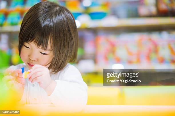 niña pequeña jugando con juguetes. - preschool building fotografías e imágenes de stock