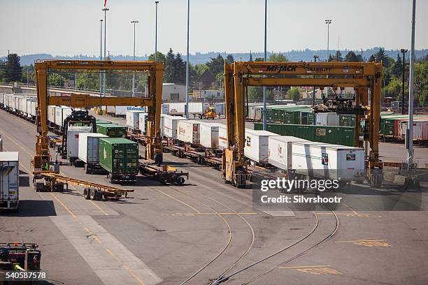 intermodal freight conainers being moved with a gantry crane. - train gantry stock pictures, royalty-free photos & images