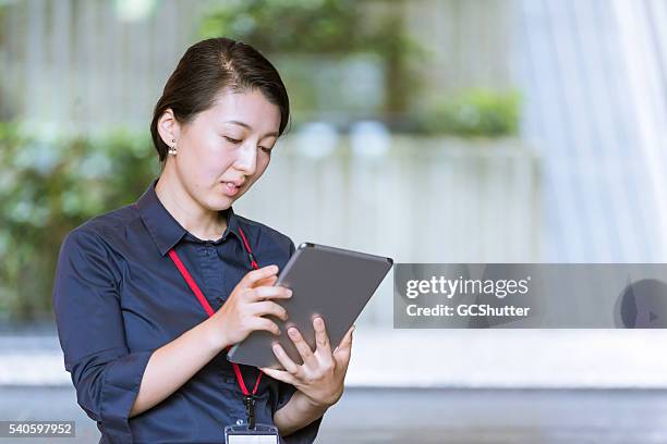 business executive surfing internet on her digital tablet - delegating 個照片及圖片檔