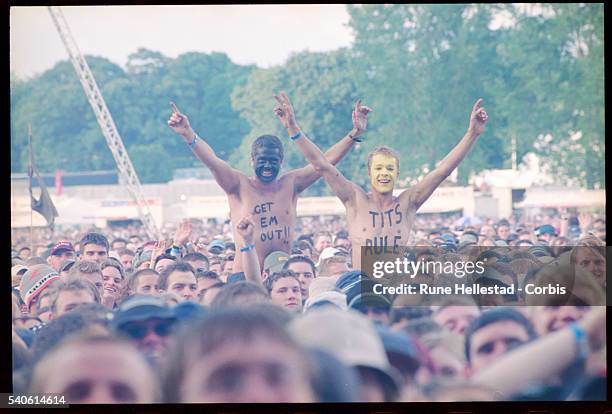 Two young men with face paint and messages painted on their chests stand out from the crowd at V2001.