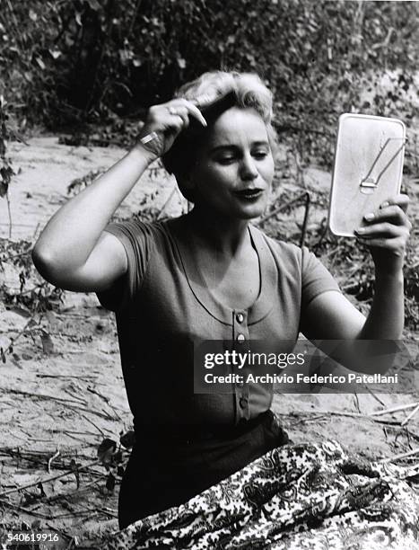 Actress Maria Schell brushes her hair while on the set of the Horst Hacler picture, Uragano sul Po.