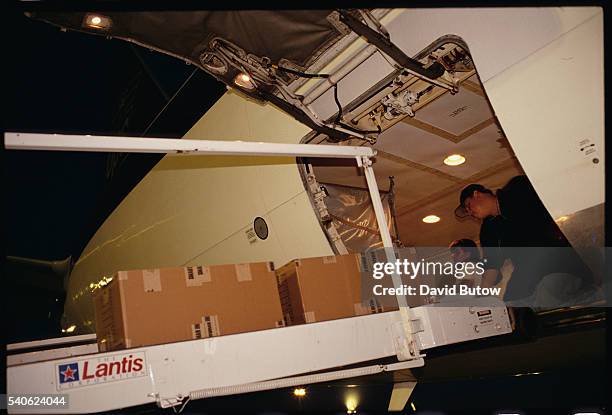 Employees load and unload a plane at the company's West Coast Air Hub in Ontario, California.